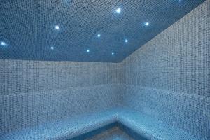 a room with a tub in a room with lights at Hotel Sancho Abarca Petit SPA in Huesca