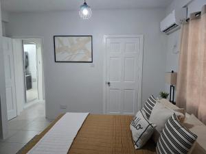 ロドニー・ベイ村にあるCozy & Cute Beach Apt Rodney Bayの白いベッドルーム(ベッド1台、白いドア付) +29枚の写真