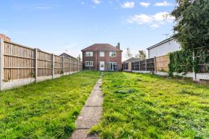 an empty yard with a fence and a house at Stylish 5 Bed in Peak District Gem - Games Rooms in Langley Mill
