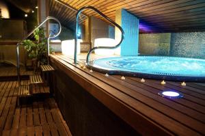 a hot tub on a wooden deck with lights at Hotel Sancho Abarca Petit SPA in Huesca