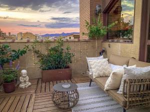 a patio with a couch and a table on a balcony at Hotel Sancho Abarca Petit SPA in Huesca