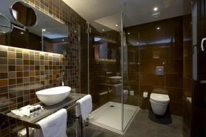 a bathroom with a sink and a toilet and a shower at Hotel Sancho Abarca Petit SPA in Huesca