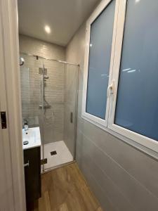 baño con ducha, lavabo y ventana en En el corazón de Pamplona, en Pamplona