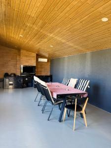 Una mesa y sillas en una habitación con techo de madera. en Cabana NORD, en Ciban 20 fotos más