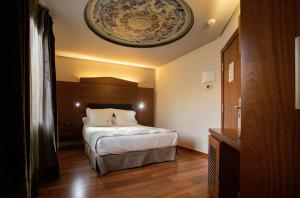 a hotel room with a bed and a ceiling at Hotel Sancho Abarca Petit SPA in Huesca