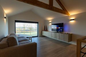 a living room with a couch and a flat screen tv at Villa Armande in Zammelen