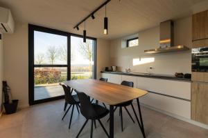 a kitchen with a wooden table and some chairs at Villa Armande in Zammelen