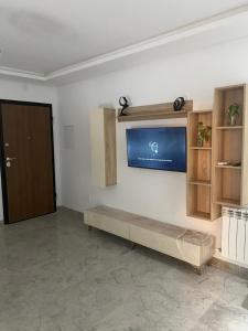un salon avec un canapé et une télévision sur un mur dans l'établissement Bo app aïn zaghouén la marsa, à La Marsa