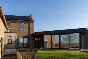 a brick house with large windows and green grass at Villa Armande in Zammelen