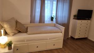 a bedroom with a couch and a dresser with a television at apartment77 in Bad Ischl