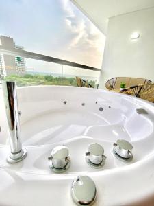 Una bañera blanca en una habitación con ventana. en Suite D’lujo: Jacuzzi privado BH, en Santa Marta