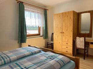 een slaapkamer met een bed, een ladekast en een raam bij Ferienwohnungen Wiedemann WE 1 in Mellenthin