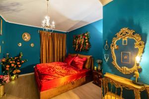 ein Schlafzimmer mit einem roten Bett und einem Spiegel in der Unterkunft Vintage Suite mit Jacuzzi und Sauna in Essen