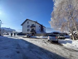 多布里尼什特Къща за гости "Тони"的雪中停放汽车的白色房子