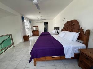 ein Schlafzimmer mit einem großen Bett mit einer lila Decke in der Unterkunft Casa Toadfish in Cozumel + 6 Fotos