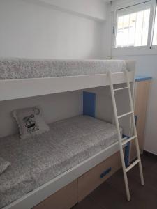 a bedroom with two bunk beds with a ladder at Xalana con terraza y magnificas vistas al mar in Girona