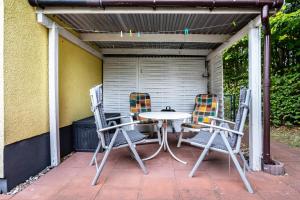 Una mesa y sillas en un patio. en Prerow Am Deich - Ferienwohnung 4, en Prerow
