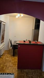 a kitchen with a red counter and a table at Apartman Aylin 2 in Tuzla