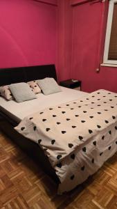 a bedroom with a large bed with black and white sheets at Apartman Aylin 2 in Tuzla