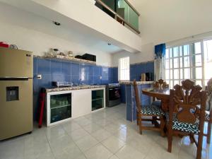 eine Küche mit blauen Schränken, einem Tisch und einem Kühlschrank in der Unterkunft Casa Toadfish in Cozumel
