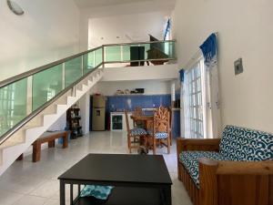 ein Wohnzimmer mit einer Treppe, einem Sofa und einem Tisch in der Unterkunft Casa Toadfish in Cozumel