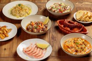 a group of bowls of food on a wooden table at NAU Sao Rafael Suites - All Inclusive in Albufeira