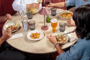 a group of people sitting around a table eating food at NAU Sao Rafael Suites - All Inclusive in Albufeira