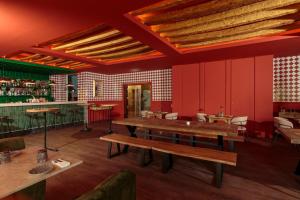 a restaurant with red walls and wooden tables at NAU Sao Rafael Suites - All Inclusive in Albufeira