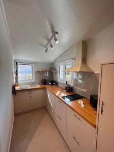 a kitchen with white cabinets and wooden counter tops at Klio Seafront House, Sami Kefalonia in Sami +37 photos