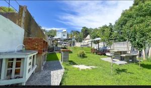 a backyard with a grill and tables and umbrellas at Cabaña La iluminada in Tandil
