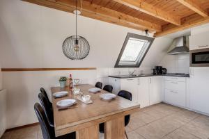 ZwiggelteにあるOrtelaan I Prettig Huis met Gezellige Tuinの木製のテーブルと椅子のあるキッチンとダイニングルーム
