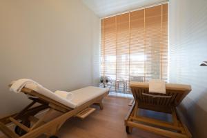 a room with a chair and a bed and a window at NAU Sao Rafael Suites - All Inclusive in Albufeira