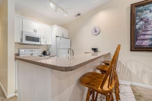 a kitchen with a counter and two chairs at a bar at Beachside 322 Waterfront Condo in Traverse City