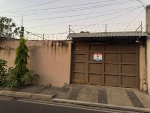 a garage door with a sign on top of it at Macaw Stay Room in Sonzacate +3 photos
