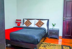 1 dormitorio con 1 cama con manta roja y azul en Mountain Breeze Apartment, en Nuwara Eliya