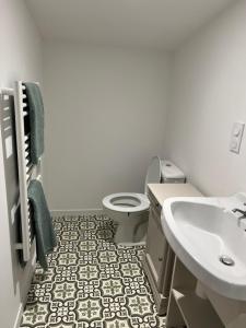 a white bathroom with a sink and a toilet at Chez Marie et Dany in Châteaumur