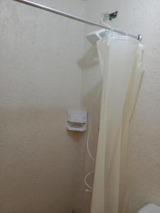 een badkamer met een douchegordijn en een toilet bij Espaço artemísia in Tramandaí +8 foto's