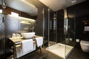 a bathroom with a sink and a shower and a toilet at Hotel Sancho Abarca Petit SPA in Huesca