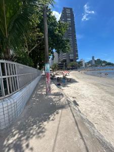 a pole on the beach with people on the sand at KIT FRENTE A PRAIA EM Sv in São Vicente
