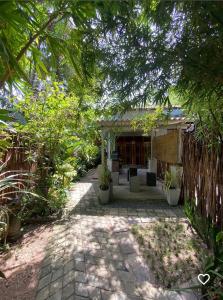 a garden with a patio with plants and a building at Dolce Vita Villa Ahangama in Ahangama
