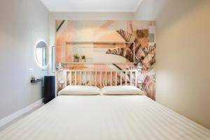 a white bed in a room with a painting on the wall at Gonfalone 6 in Rome