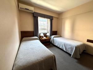 a hotel room with two beds and a window at Hotel Centro Naval in Buenos Aires
