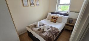 a bedroom with a bed with two candles on it at SAV Stays Apartment Two Bed Flat Uxbridge in Uxbridge