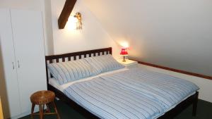 a bed with a blue striped comforter in a room at Guest House Melusine in Loučná pod Klínovcem