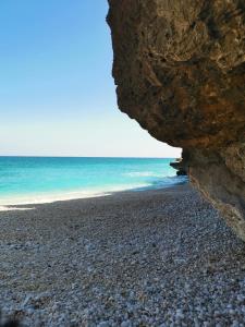 a rocky beach with the ocean behind a large rock at ROYAl FINS CAMP in Fins