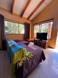 een woonkamer met 2 bedden en een flatscreen-tv bij Casa de Costa, Campo y Relax in Algarrobo