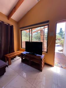 een woonkamer met een flatscreen-tv en een groot raam bij Casa de Costa, Campo y Relax in Algarrobo