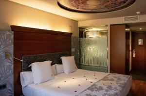 a bedroom with a bed with red flowers on it at Hotel Sancho Abarca Petit SPA in Huesca