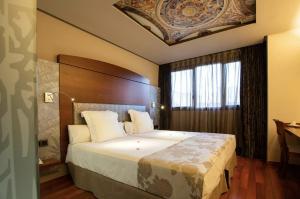 a bedroom with a large bed with a wooden headboard at Hotel Sancho Abarca Petit SPA in Huesca