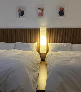 two beds in a hotel room with two lamps and two beds sidx sidx sidx at Our Stay in Seoul
